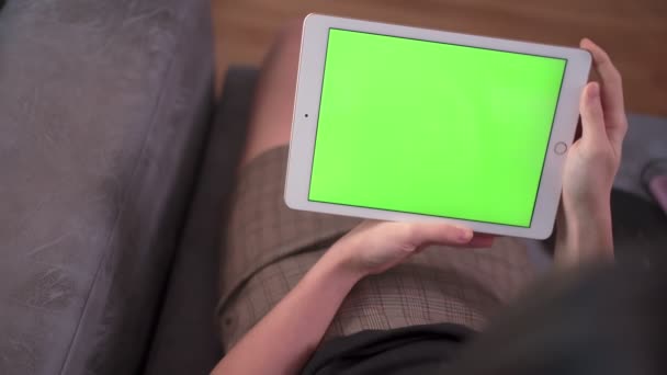以上の肩の女性が白いタブレットを使用してソファの上に座るホームルームリビングルームで緑の画面 無線ネットワーク接続 ホーム隔離 緑の画面技術コンセプト ホームリラクゼーション — ストック動画