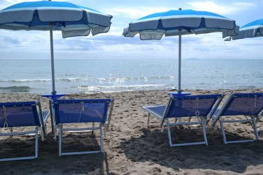 Denize, sahile, güneşliğe ve şemsiyelere