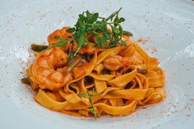 Beyaz tabakta domatesli erişte.