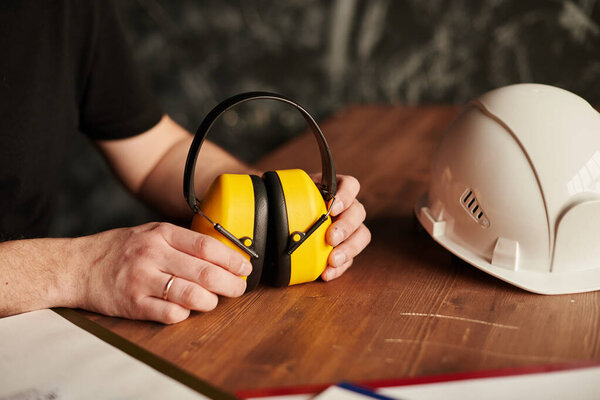 Мужские руки шумят отменяя наушники каска
