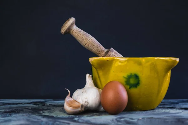 Bir kase sarımsak ve yağlı sos, yumurta, yağ ve sarımsak.