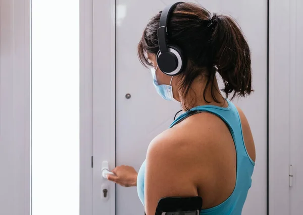 Kız dışarı çıkıp mavi bir maskeyle spor yapmaya hazırlanıyor.