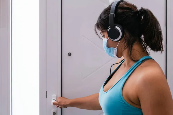 Kız dışarı çıkıp mavi bir maskeyle spor yapmaya hazırlanıyor.