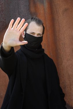 Şehrin sokaklarında maske takan yakışıklı bir adam. Grip virüsü veya koronavirüs enfeksiyonuna karşı korunmak için solunum cihazına bağlı bir gencin yakın çekimi.