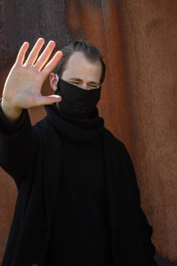 Şehrin sokaklarında maske takan yakışıklı bir adam. Grip virüsü veya koronavirüs enfeksiyonuna karşı korunmak için solunum cihazına bağlı bir gencin yakın çekimi.