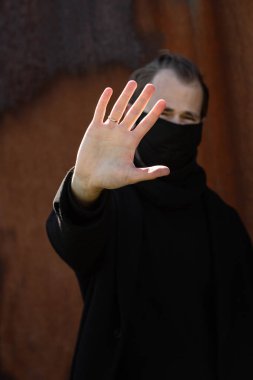 Şehrin sokaklarında maske takan yakışıklı bir adam. Grip virüsü veya koronavirüs enfeksiyonuna karşı korunmak için solunum cihazına bağlı bir gencin yakın çekimi.