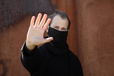 Şehrin sokaklarında maske takan yakışıklı bir adam. Grip virüsü veya koronavirüs enfeksiyonuna karşı korunmak için solunum cihazına bağlı bir gencin yakın çekimi.