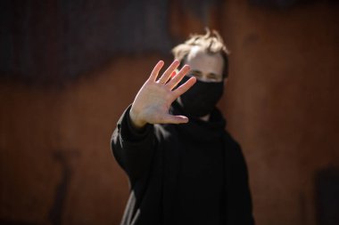 Şehrin sokaklarında maske takan yakışıklı bir adam. Grip virüsü veya koronavirüs enfeksiyonuna karşı korunmak için solunum cihazına bağlı bir gencin yakın çekimi.