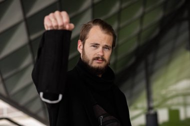 Şehrin sokaklarında maske takan yakışıklı bir adam. Grip virüsü veya koronavirüs enfeksiyonuna karşı korunmak için solunum cihazına bağlı bir gencin yakın çekimi.