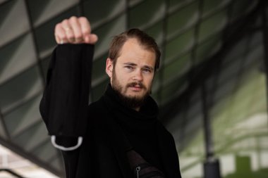 Şehrin sokaklarında maske takan yakışıklı bir adam. Grip virüsü veya koronavirüs enfeksiyonuna karşı korunmak için solunum cihazına bağlı bir gencin yakın çekimi.