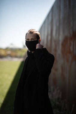 Şehrin sokaklarında maske takan yakışıklı bir adam. Grip virüsü veya koronavirüs enfeksiyonuna karşı korunmak için solunum cihazına bağlı bir gencin yakın çekimi.