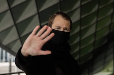 Şehrin sokaklarında maske takan yakışıklı bir adam. Grip virüsü veya koronavirüs enfeksiyonuna karşı korunmak için solunum cihazına bağlı bir gencin yakın çekimi.