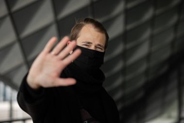 Şehrin sokaklarında maske takan yakışıklı bir adam. Grip virüsü veya koronavirüs enfeksiyonuna karşı korunmak için solunum cihazına bağlı bir gencin yakın çekimi.