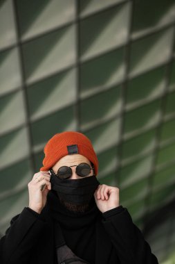 Şehrin sokaklarında maske takan yakışıklı bir adam. Grip virüsü veya koronavirüs enfeksiyonuna karşı korunmak için solunum cihazına bağlı bir gencin yakın çekimi.