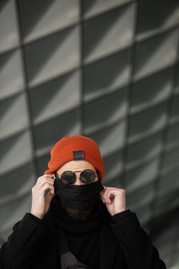 Şehrin sokaklarında maske takan yakışıklı bir adam. Grip virüsü veya koronavirüs enfeksiyonuna karşı korunmak için solunum cihazına bağlı bir gencin yakın çekimi.