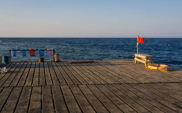 Kırmızı bayrak ahşap iskele üzerinde — Stok fotoğraf