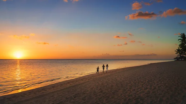 Lopers op het strand bij zonsondergang — Stockfoto