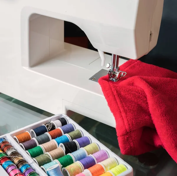 Máquina de coser blanca y tela roja — Foto de Stock
