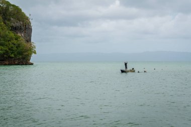 Balıkçı teknede balık tutuyor.