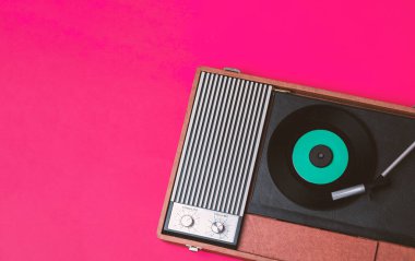 Retro vinil çalar ve fuşya arka planında döndürülebilir. Eğlence 70 'ler. Müzik dinle. Üst görünüm.