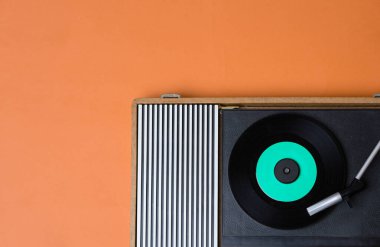 Retro vinil çalar ve sarı arka planda döndürülebilir. Eğlence 70 'ler. Müzik dinle. Üst görünüm.