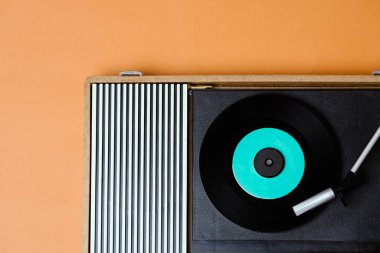 Retro vinil çalar ve sarı arka planda döndürülebilir. Eğlence 70 'ler. Müzik dinle. Üst görünüm.