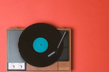 Eski vinil çalar ve turuncu arka planda döndürülebilir. Eğlence 70 'ler. Müzik dinle. Üst görünüm.