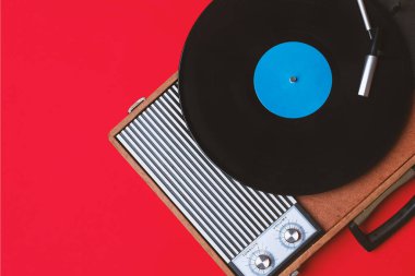 Eski vinil çalar ve kırmızı arka planda döndürülebilir. Eğlence 70 'ler. Müzik dinle. Üst görünüm.