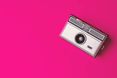 Fuşya arka planında eski bir fotoğraf makinesi.