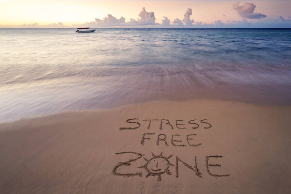 Handwritten Stress free zone on sandy beach at sunset,relax and summer concept,Dominican republic beach.