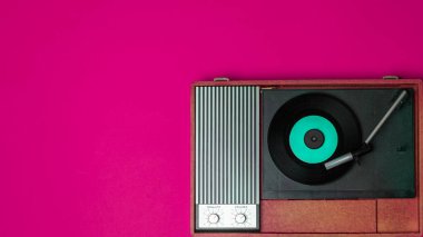 Eski bir vinil çalar ve fuşya arka planında döndürülebilir. Eğlence 70 'ler. Müzik dinle. Üst görünüm.