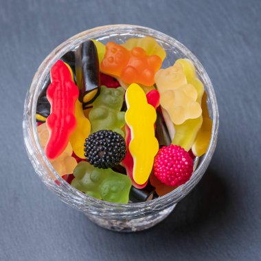 Cam bir fincanın içindeki koyu renkli şekerler. Selamlamalarınız için en üstte boşluk