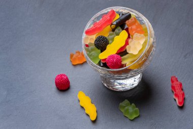 Cam bir fincanın içindeki koyu renkli şekerler. Selamlamalarınız için en üstte boşluk