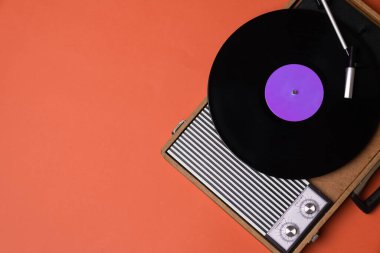 Vinil çalar ve turuncu arka planda döndürülebilir. Eğlence 70 'ler. Müzik dinle. Üst görünüm.