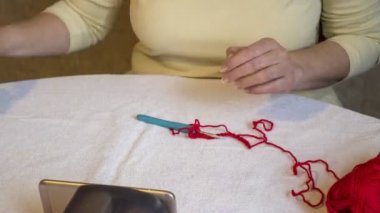 İnternette cep telefonu teknolojisi kullanarak örgü örme üzerine bir video dersi veriyor. Koronovirüs salgını sırasında Rusya 'da uzaktan öğrenme. Zaman atlaması. 4K, 3840x2160.