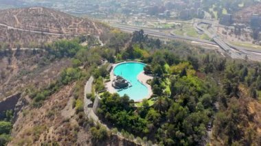 Santiago de Chile Metropolitan Parkı 'ndaki Cerro Chacarillas' ın ortasında bulunan Tupahue Havuzu 'nun insansız hava aracı havuz manzaralı.