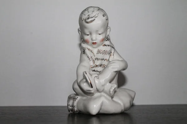 Porcelain Figurine Boy Puts Auf Einem Sandal — Stockfoto