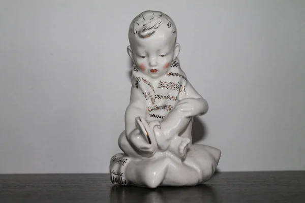 Porcelain Figurine男の子はサンダルに置きます — ストック写真