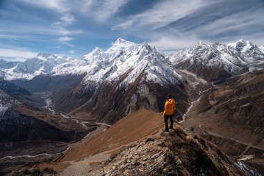 Trekker, Manaslu 'nun Manaslu çevre yürüyüşü, Himalaya' nın Asya, Nepal bölgesindeki Samdo Ri 'nin tepesinde duruyor.