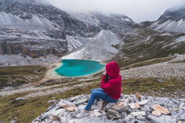 Sichuan, Chaina, Asya 'daki Yading Ulusal Parkı' nda süt gölüne bakan bir kadın.