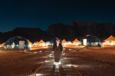 Wadi Rum Çölü, Ürdün, Asya 'da Mars Kubbesi' nin önünde çadır kuran bir adam.