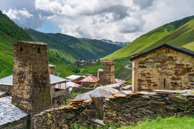 Yaz mevsiminde Ushguli köyündeki Svaneti geleneksel kulesi Gürcistan 'ın Svaneti bölgesindeki Kafkas sıradağlarıyla çevrilidir.