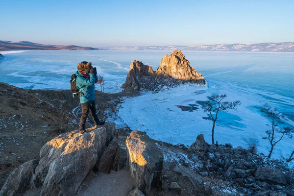 Sırt çantalı bir fotoğrafçı bir sabah Baykal donmuş gölünün fotoğrafını çekiyor, Olkhon adası, Sibirya, Rusya, Asya