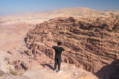 Petra harabelerinde ve Ürdün, Arap ve Asya 'daki antik şehirlerde, dağın tepesinde durup poz veren bir adam.