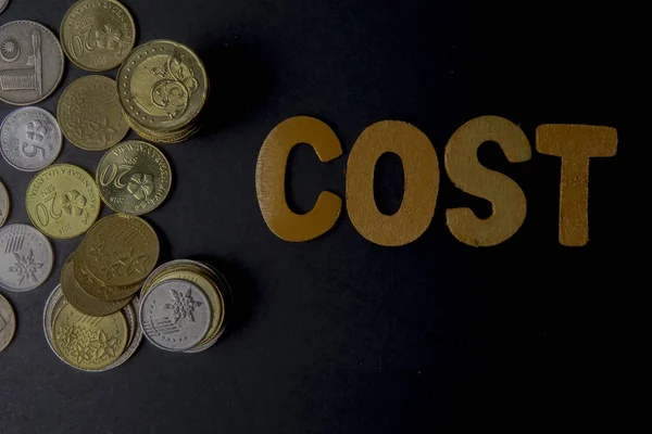 Paire de ciseaux réduit les dépenses d'affaires mot COST pour économiser le coût. Concept d'entreprise et faible luminosité . — Photo