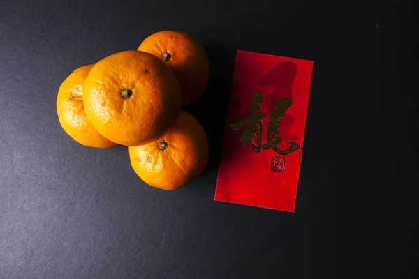 Decoraciones del festival de año nuevo chino, paquetes rojos y naranjas mandarín, carta china de oro significa suerte — Foto de Stock