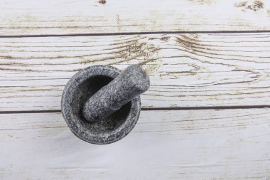 Taş harç ve ahşap arka plan üzerinde izole havaneli.