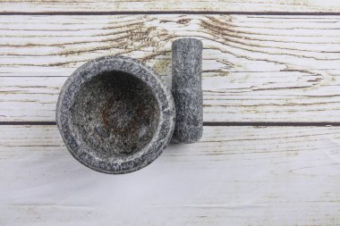 Taş harç ve ahşap arka plan üzerinde izole havaneli.