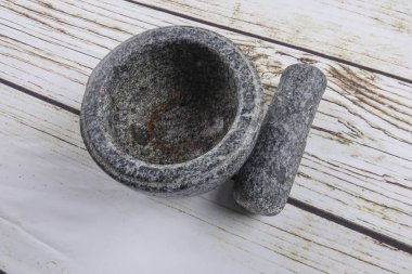 Taş harç ve ahşap arka plan üzerinde izole havaneli.