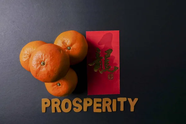 Slovo z Prosperity, ang pow nebo červená pakety a mandarinky, zlaté čínské dopis znamená štěstí — Stock fotografie